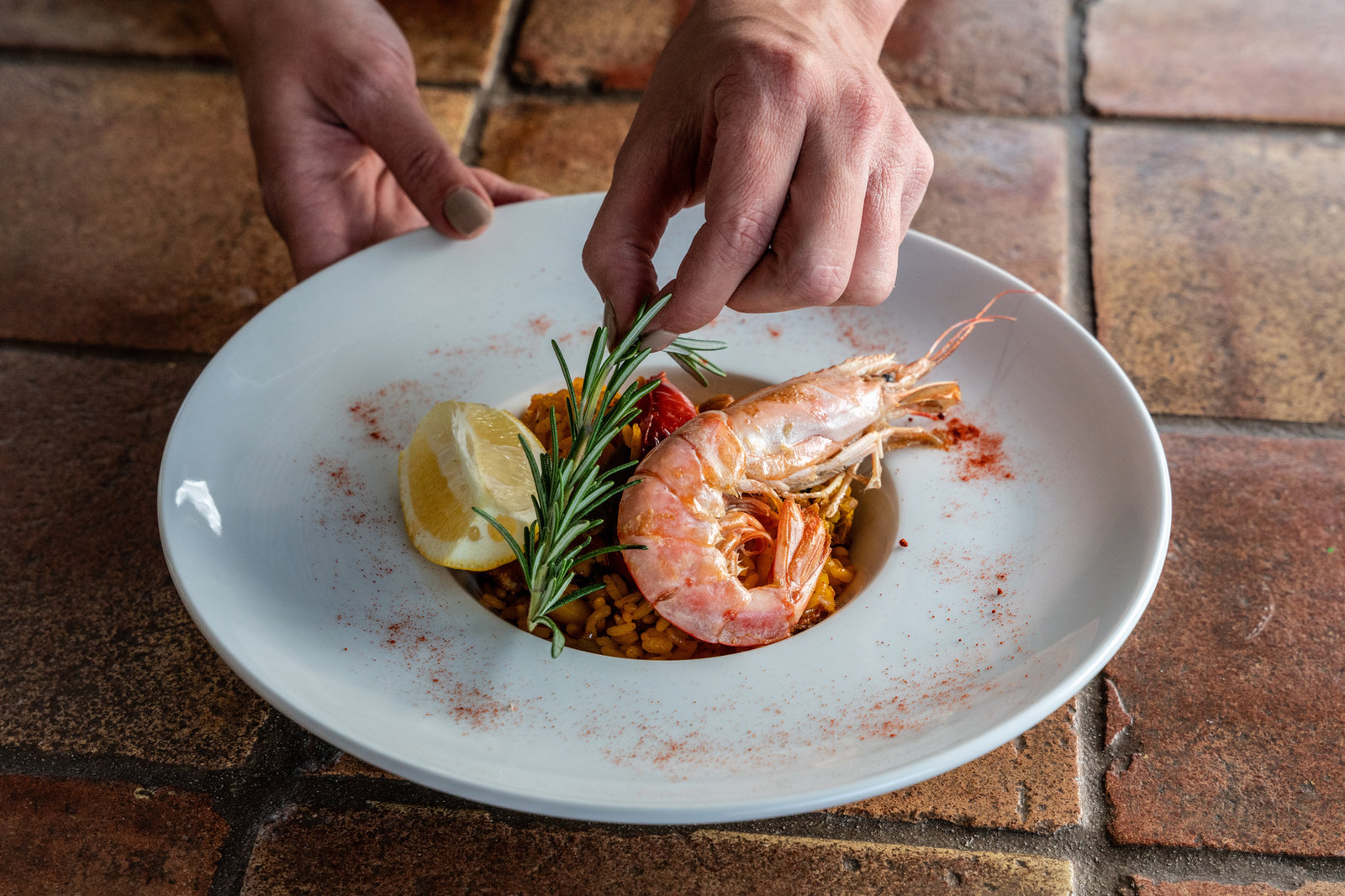 A plated dish of langoustines with rosemary at Cuatre Finques