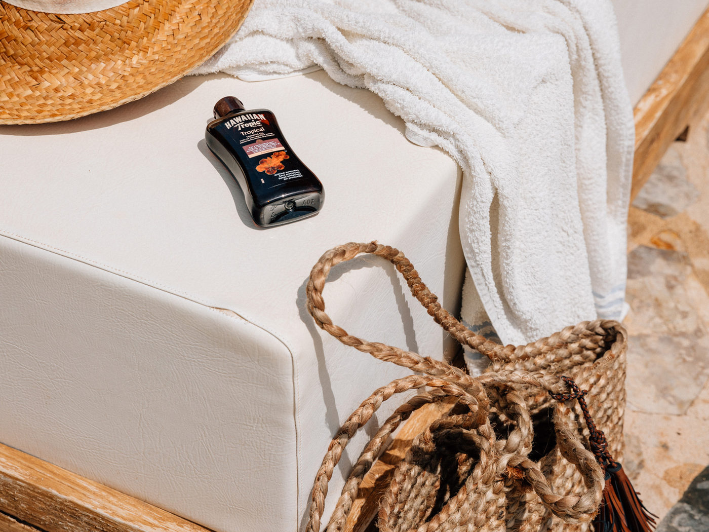 Folded towel and a woven bag on a sun lounger